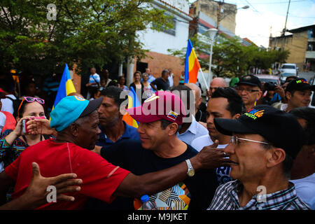 26 März 2018, Venezuela, Caracas: Kandidat der Opposition Henri Falcon (2. von links) gruss Unterstützer während man durch die Straßen der Armenviertel von Petare. Der ehemalige Gouverneur brach der Boykott, der von den wichtigsten Opposition Koalition, Schlamm, und Angemeldet als Präsidentschaftskandidaten. Maduro sucht für eine Amtszeit endet im Jahr 2025 während der kommenden Wahlen vom 20. Mai wiedergewählt werden. Beobachter befürchten, dass die Wahlen weder frei noch fair. Foto: Wil Riera/dpa Stockfoto