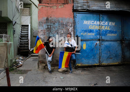 26 März 2018, Venezuela, Caracas: Anhänger der Kandidat der Opposition, Henri Falcon, die nationale Flaggen während des Wartens auf einen Besuch von Falcon an die Elendsviertel von Petare. Der ehemalige Gouverneur brach der Boykott, der von den wichtigsten Opposition Koalition, Schlamm, und Angemeldet als Präsidentschaftskandidaten. Maduro sucht für eine Amtszeit endet im Jahr 2025 während der kommenden Wahlen vom 20. Mai wiedergewählt werden. Beobachter befürchten, dass die Wahlen weder frei noch fair. Foto: Wil Riera/dpa Stockfoto