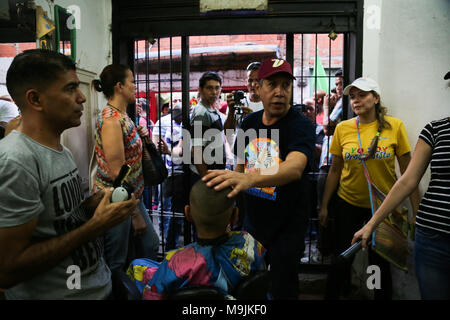 26 März 2018, Venezuela, Caracas: Kandidat der Opposition Henri Falcon (C) Gespräch mit dem Kunden ist ein Friseursalon im Slum von Petare. Der ehemalige Gouverneur brach der Boykott, der von den wichtigsten Opposition Koalition, Schlamm, und Angemeldet als Präsidentschaftskandidaten. Maduro sucht für eine Amtszeit endet im Jahr 2025 während der kommenden Wahlen vom 20. Mai wiedergewählt werden. Beobachter befürchten, dass die Wahlen weder frei noch fair. Foto: Wil Riera/dpa Stockfoto