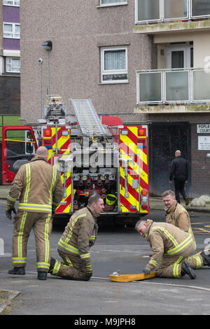Leeds, Großbritannien. 27 März 2018, Leeds, Großbritannien. Feuerwehrmänner und Forscher auf die Szene an Pappel Court 2 Tower Block in der Gegend von Leeds Bramley, wo ein Mann, Frau und Kind ins Krankenhaus nach einem Brand in einer Wohnung im 8. Stock heute früh genommen wurden. Credit: James Copeland/Alamy leben Nachrichten Stockfoto