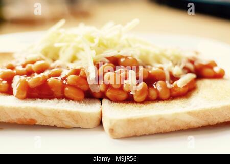 Gebackene Bohnen auf Toast überbacken mit Geriebener Cheddar-Käse Stockfoto