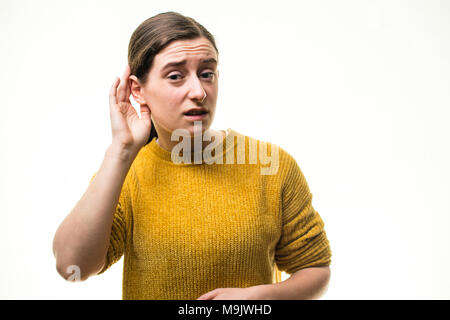 Verlust der Hörfähigkeit: Eine junge Kaukasier frau mädchen Schröpfen die Hand auf ihr Ohr und versucht, um einen Ton zu hören, auf einem weißen Hintergrund, Großbritannien Stockfoto