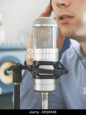 Der Mensch in der Nähe von Mikrofon im Tonstudio. Stockfoto