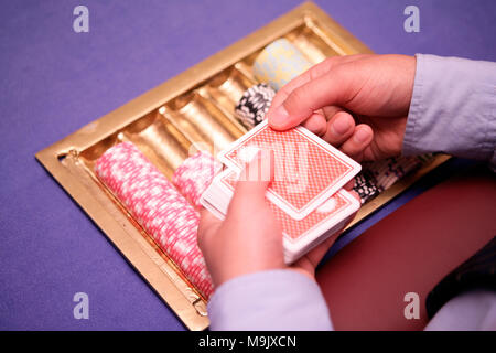 Nahaufnahme von holdem Dealer mit Spielkarten und Chips auf blauen Tabelle Stockfoto