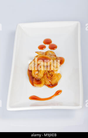 Nachtisch aus gebratenen Bananen in Scheiben schneiden und mit flüssigem Caramel auf der Oberseite isoliert auf weißem schneiden. Stockfoto