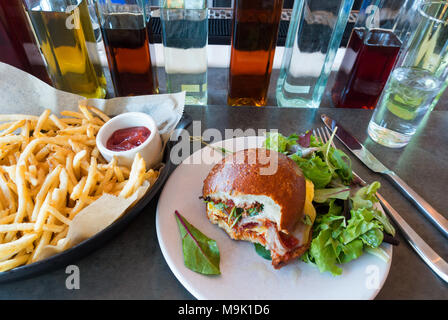 Ei und Speck Sandwich auf einer weichen gerösteten Brötchen mit Salat und Pommes frites Stockfoto