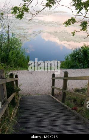 Treppen aus Holz, die mit einem Vorratsbehälter, wo der Himmel in einem späten Nachmittag reflektiert wird. Stockfoto