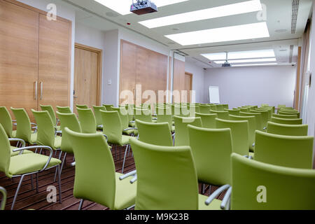 Innenraum der Großen Konferenzsaal mit vielen grünen komfortable Sitze und Flipchart auf dem Hintergrund der Schuß. Zimmer mit toller Aussicht Stockfoto