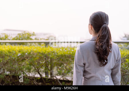 Office Lady im Anzug in den Garten und dachte, das Projekt. Auf der Rückseite anzuzeigen. Stockfoto
