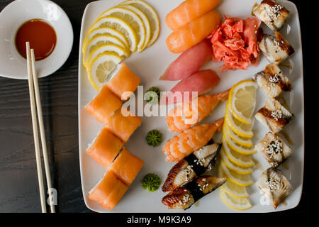 Ansicht von oben geschossen von verschiedenen Arten von lecker Sushi und Brötchen mit Stäbchen. marine Produkte. Variation von Sushi. Vitamine und Mineralien Stockfoto