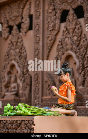 Kanchanaburi, Thailand - Dezember 14, 2014: Mädchen mit traditioneller Kleidung falten Lotus petal für zu verehren Buddha Bild in der Buddhistischen Kirche verwendet wird Stockfoto