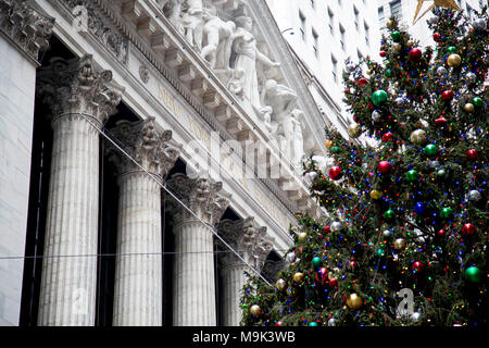 Ein riesiger Weihnachtsbaum außerhalb Säulenportikus, der New York Stock Exchange Gebäude und Fassade in Manhattans Finanzdistrikt eingerichtet. Stockfoto