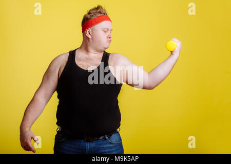 Fetter Mann mit schwarzen Shirt Training mit Hanteln und Bizeps Stockfoto