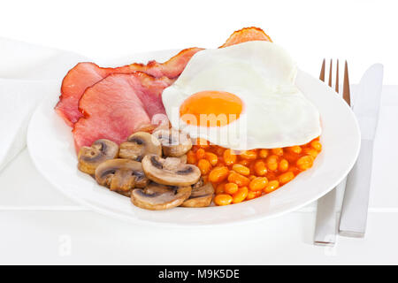 Frühstück - Englisch Frühstück mit Speck, Ei, Champignons und Bohnen auf einen Teller legen und bereit, mit dem Wort Frühstück zu essen. Stockfoto