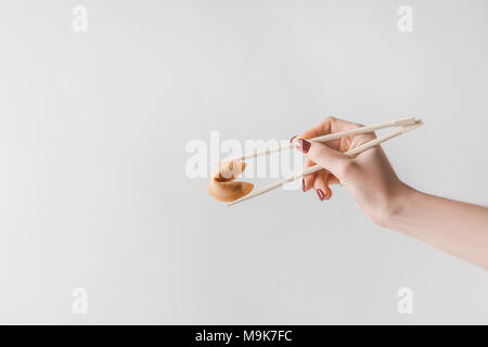 Zugeschnittenes Bild der Frau mit chinesischen Glückskeks mit Stäbchen isoliert auf weißem Stockfoto