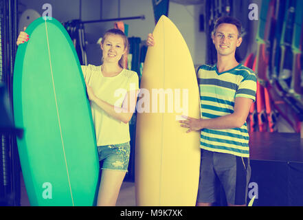 Nettes Paar zeigt bunte Platten in Store am Strand Stockfoto