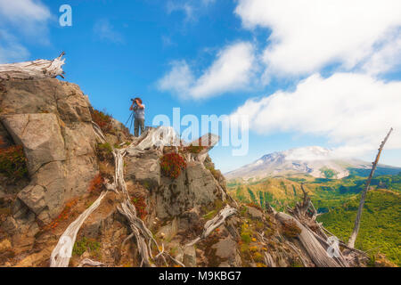 Ein Wanderer/Fotograf sieht durch seine Kamera von oben auf Castle Peak, mit Mt. St. Helens im Hintergrund Gifford Pinchot National Forest Stockfoto