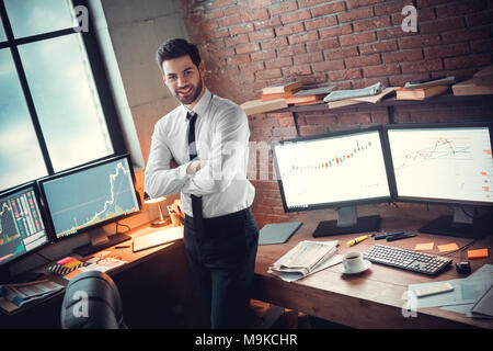 Junger bärtiger Mann Händler im Büro stehen gekreuzte Arme zur Seite schauen, lächeln sicher glücklich, erfolgreicher Geschäftsmann Stockfoto
