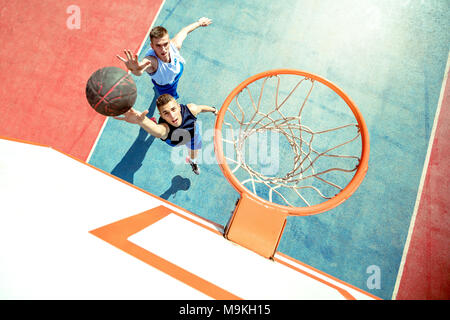 Hohe Betrachtungswinkel der Basketballspieler dunking Basketball in Hoop Stockfoto