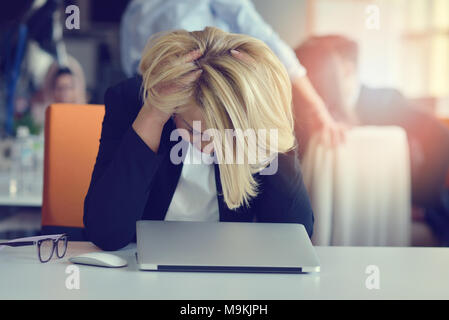 Müde und gestresst. Frustriert erwachsenen Frau die Augen vor Müdigkeit beim Sitzen im Büro geschlossen. Stockfoto