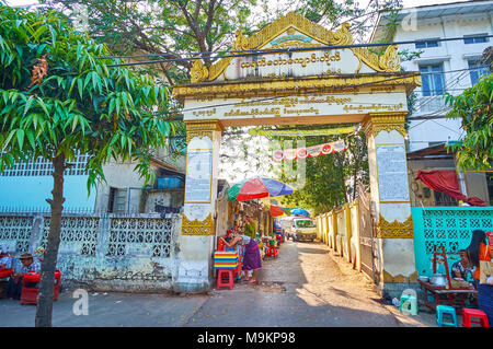 YANGON, MYANMAR - Februar 14, 2018: Das alte Tor von Thayet Taw buddhistischen Komplexen, mit goldenen Inschriften und Muster, Chinatown eingerichtet, auf Firma Febru Stockfoto