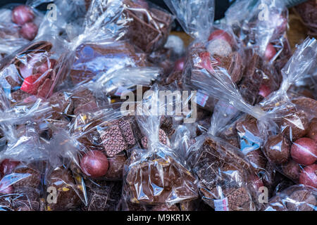 Ostern Schokolade und Eier high class Schokolade Süßwaren in durchsichtigen Wrapper in farbiges Papier gewickelt. Spezialitäten zum Verkauf auf einem Stall. Stockfoto