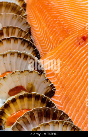 Jakobsmuscheln und frischen Lachs auf einem fischhändler am Borough Market in Central London. Frischen Fang des Tages Schalentiere und Rot Lachs zum Verkauf Zähler Stockfoto