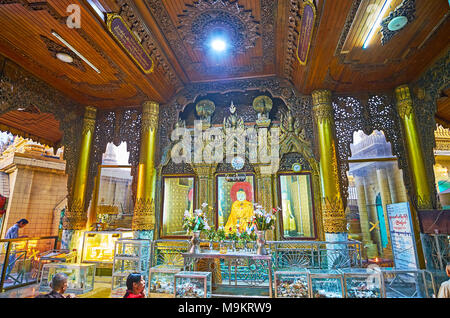 YANGON, MYANMAR - Februar 14, 2018: Der Komplex der innerdekoration von Bild Haus - die aus Holz geschnitzte Muster und riesigen goldenen Säulen rund um die Stockfoto