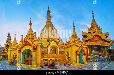 YANGON, MYANMAR - Februar 14, 2018: Abend Panorama der Sule Pagode mit herrlichem goldenen Stupa, viele kleine Schreine und Bild Häuser, am 14. Februar in Stockfoto