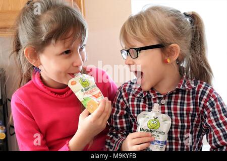 Schwestern genießen Buddy Obst in der Küche Stockfoto