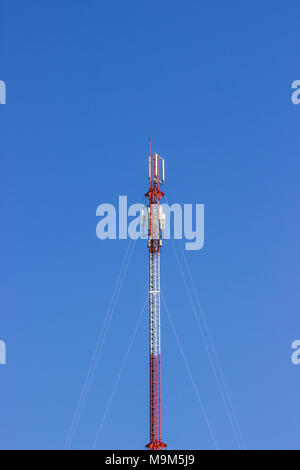 Rote und weiße Telekommunikationsturm in einem Tag der klare, blaue Himmel. Telefonmast Stockfoto