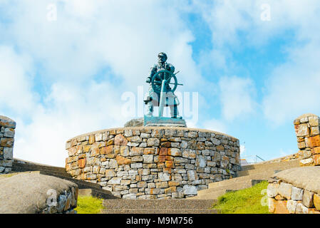 Statue im Gedächtnis von lifeboatman Richard (DIC) Evans neben dem Rettungsboot station in Moelfre, Anglesey, Wales. Die Statue wurde von Sam Holland erstellt Stockfoto