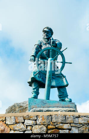 Statue im Gedächtnis von lifeboatman Richard (DIC) Evans neben dem Rettungsboot station in Moelfre, Anglesey, Wales. Die Statue wurde von Sam Holland erstellt Stockfoto