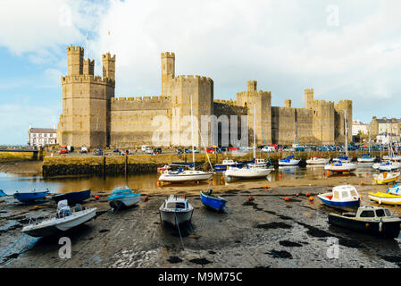 Boote bei Ebbe unter Caernarfon Castle, Gwynedd, Wales Stockfoto