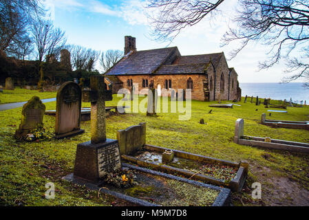 Die mittelalterliche Kirche St. Peter, Heysham, Lancashire, mit Morecambe Bay über Stockfoto