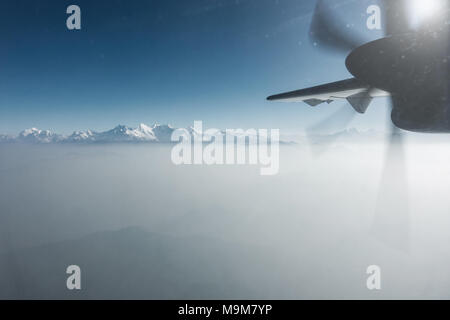 Der Himalaya als von einem Propeller Flugzeug in Nepal gesehen. Schicht von Wolken unter dem Berggipfel. Stockfoto