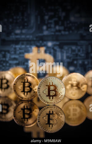 Viele gold Bitcoins bleiben auf reflektierende Oberfläche mit einem einzigen Bitcoin scharf Stockfoto
