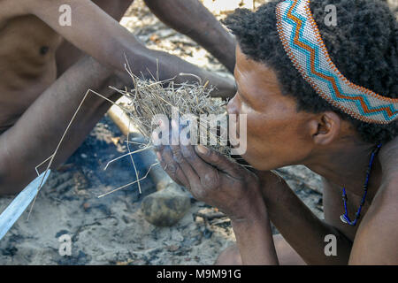 San Stamm Buschmänner, auch bekannt als der Erste Stamm von Afrika, Feuer machen die traditionelle Art und Weise in die umliegende Buschland in Namibia. Stockfoto