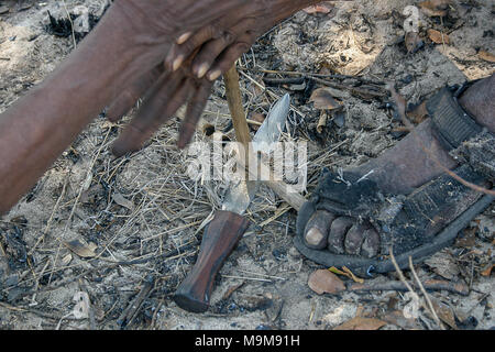 San Stamm Buschmänner, auch bekannt als der Erste Stamm von Afrika, Feuer machen die traditionelle Art und Weise in die umliegende Buschland in Namibia. Stockfoto