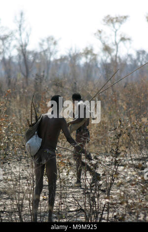 San Stamm Buschmänner, die auch als der erste Stamm von Afrika, Jagd in den umliegenden Buschland in Namibia bekannt Nach einem Buschfeuer. Stockfoto