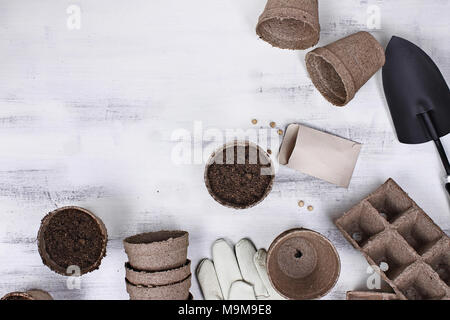 Gartengeräte, Samen und Erde auf eine weiße Holztisch. Bild geschossen von oben im flachen Stil legen. Stockfoto