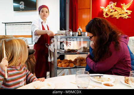 Eine chinesische Dame Essen aus Ihrem dim sum Trolley im berühmten Restaurant Ruby Rouge in Montreal's Chinatown Stockfoto