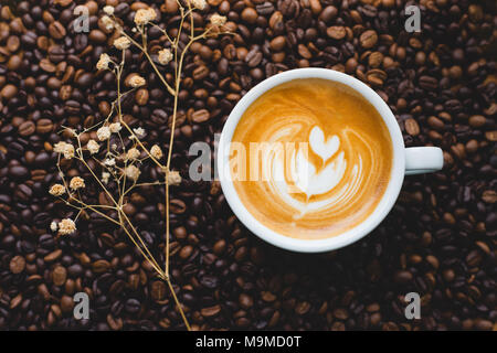Latte Art Kaffee auf Kaffeebohnen, Ansicht von oben Bild Stockfoto