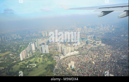 Ein Blick auf die Stadt von Manila durch das Fenster aus dem Flugzeug. Foto von einem Touristen im Flug über die Hauptstadt beeindruckt. Philippinen. Stockfoto