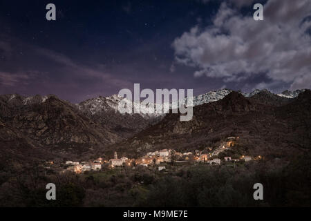 Das Dorf Feliceto in der Balagne Korsika unter einem Stern gefüllt moonlit Sky mit Schnee bedeckte Berge in der Ferne Stockfoto