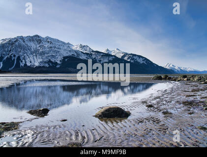 Chilkat Berge in Wasser in der Gezeiten- Mündung des Chilkat Einlass im Winter wider. Stockfoto