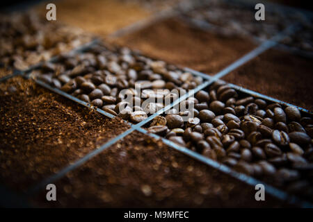 Holzkiste mit drei Arten von Kaffeebohnen und gemahlenen Kaffee Stockfoto