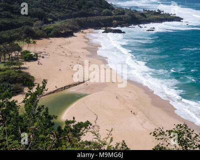 Waimea Bay Beach Park von oben: Der feine Sand von Waimea Bay Strand bevölkert von vielen Strandurlauber beobachten Die wavews. Keine Schwimmen wegen der starken Wellengang in den blauen Ozean. Stockfoto