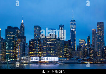 Die Skyline von Lower Manhattan über den East River zeigt die Lichter der Stadt und die hellen Lichter am Pier 17 Stockfoto