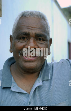 Alter Mann außerhalb seines beschädigten Hauses, Suva, Fidschi. Stockfoto